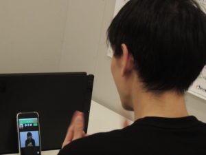 電話リレーサービスを使って手話で電話をしている写真